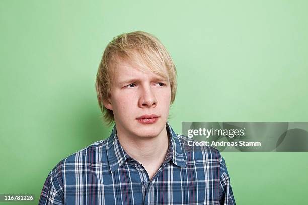 a teenage boy looking off to the side with suspicion, portrait, studio shot - angry teenager stock pictures, royalty-free photos & images