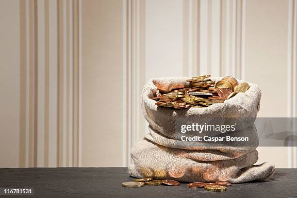 large sack full of euro coins on a table - sack stockfoto's en -beelden