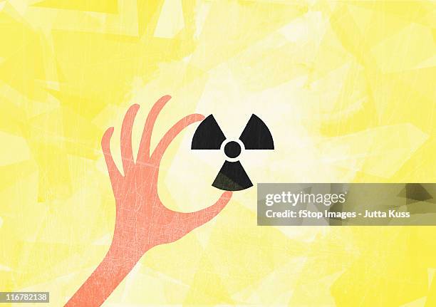 a hand holding a radioactive symbol - radioactive warning symbol 幅插畫檔、美工圖案、卡通及圖標
