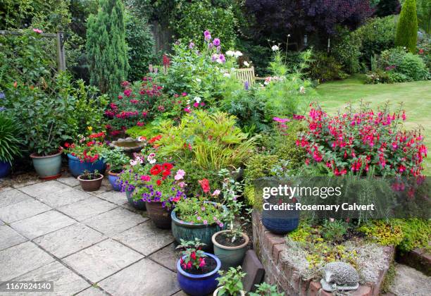 patio & flowerbed bright with flowers in english garden. - vaso de flor imagens e fotografias de stock