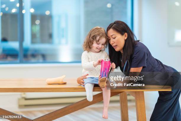 klein meisje met prothetische been op medische afspraak - artificial limb stockfoto's en -beelden