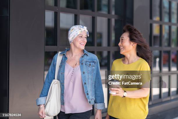 woman with cancer enjoys precious time with a friend - cancer center stock pictures, royalty-free photos & images