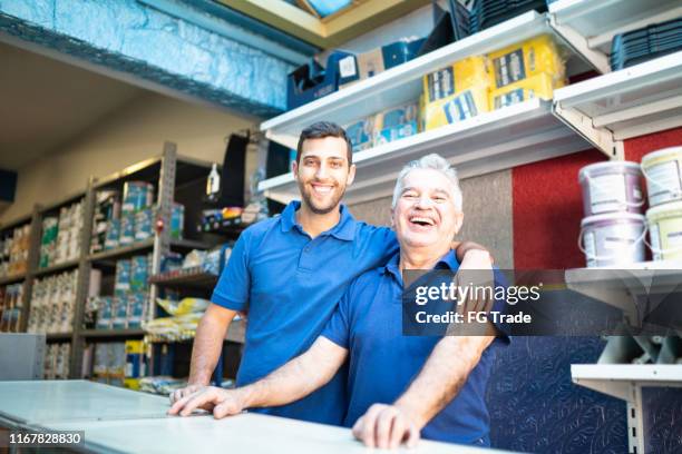 vater und sohn arbeiten in einem lackiergeschäft zusammen - father son business stock-fotos und bilder