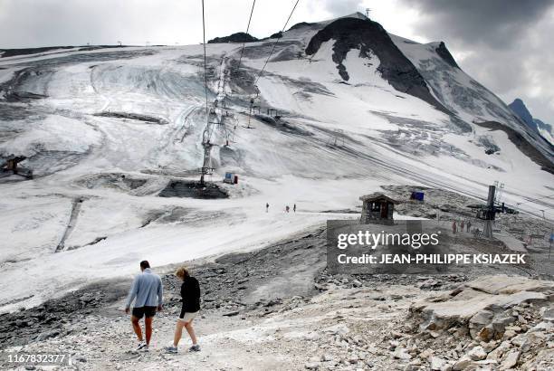 Un couple se promène sur le glacier de la grande Motte à 3.406 mètres d'altitude, le 28 juillet 2007 à Tignes. Face à la répétition des périodes de...