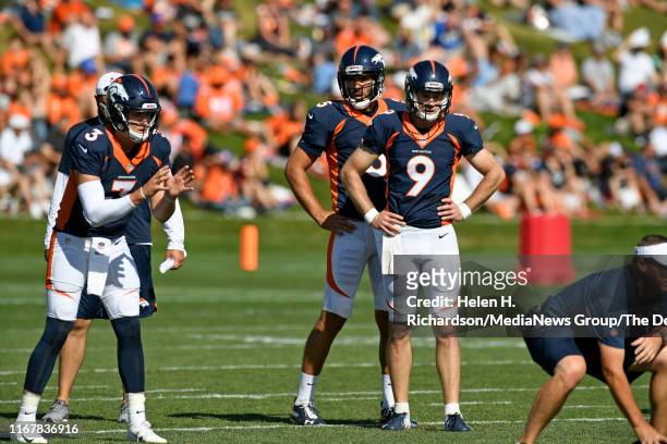 Denver Broncos quaterbacks from left to right Drew Lock, #3, Joe Flacco, #5, and Kevin Hogan, #9, take turns during throwing drills at training camp...
