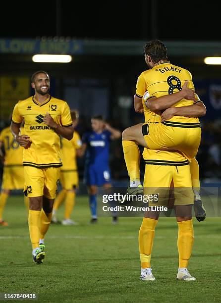 Alex Gilbey of MK Dons is congratulated after scoring the winning penalty during the Carabao Cup First Round match between AFC Wimbledon and Milton...