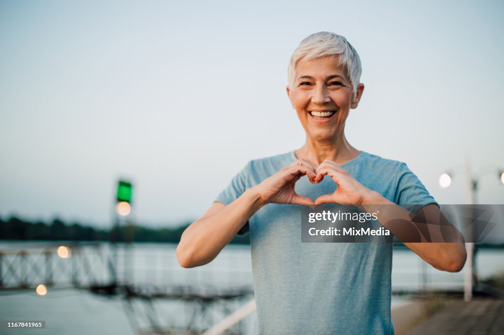 Actieve Senior vrouw het maken van een hart met haar handen