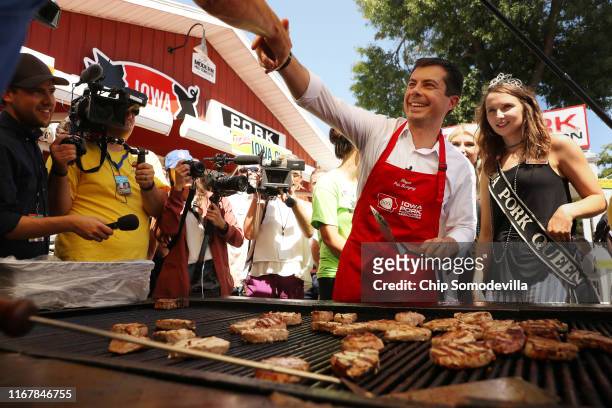 Democratic presidential candidate and South Bend, Indiana, Mayor Pete Buttigieg gets a little grilling guidance from Iowa Pork Queen Gracie Greiner...