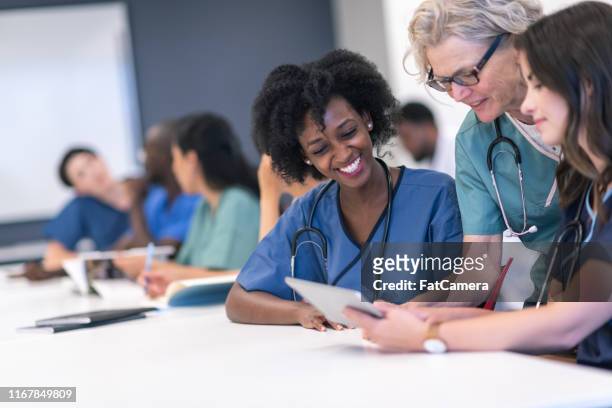 senior vrouwelijke docent begeleidt medische studenten tijdens de les - a celebration of arts education stockfoto's en -beelden