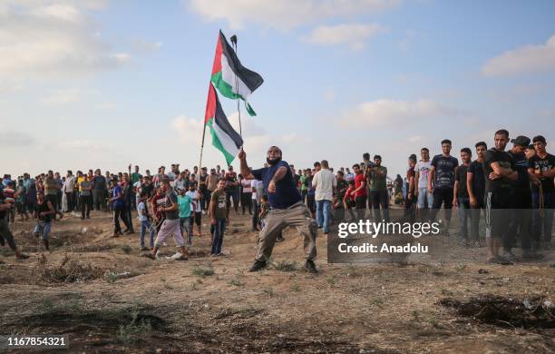 Palestinian uses a slingshot to throw stones in response to Israeli forces's intervention during "Great March of Return" demonstration at Israel-Gaza...