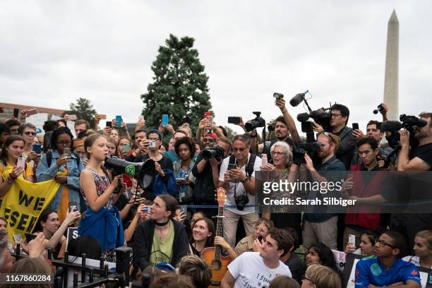 Teenage Swedish climate activist Greta Thunberg delivers brief remarks surrounded by other student environmental advocates during a strike to demand...