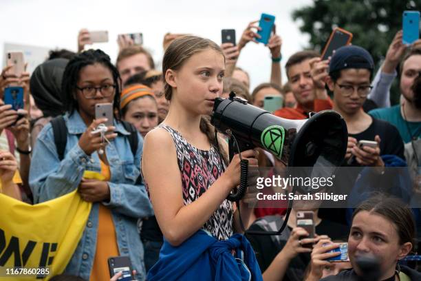 Teenage Swedish climate activist Greta Thunberg delivers brief remarks surrounded by other student environmental advocates during a strike to demand...