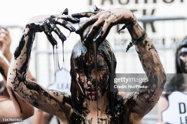 Activists douse themselves with black &quot;toxic slime&quot; outside London Fashion Week's main venue on The Strand on 13 September, 2019 in London,...