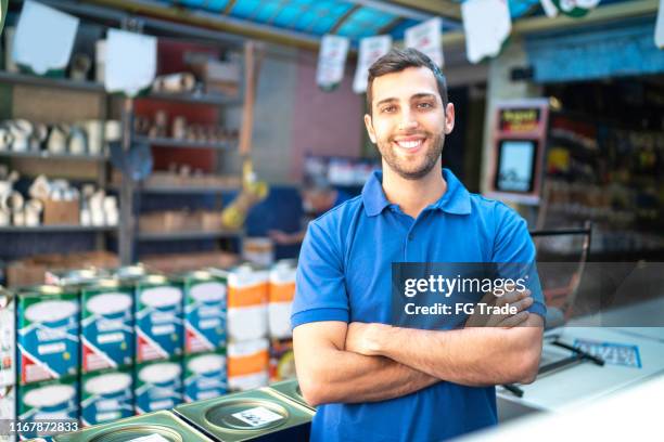 retrato de un joven vendedor de pie en una tienda de pintura - salesman fotografías e imágenes de stock