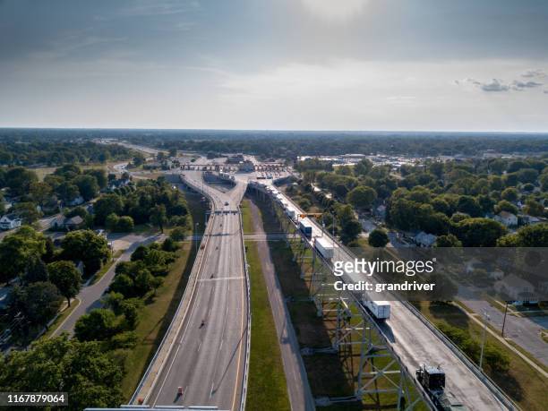 an aerial view of a line of semi trucks waiting at the canadian border to enter the usa - canada v united states stock pictures, royalty-free photos & images