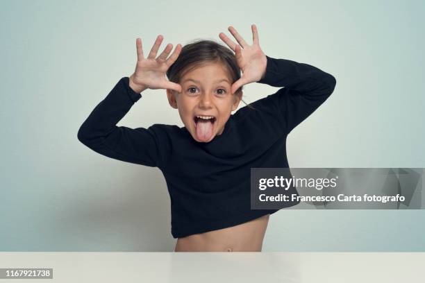 little girl making a funny face - sticking out tongue stock-fotos und bilder