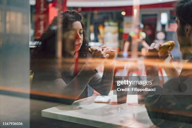 amici adolescenti seduti al fast food insieme - fast food restaurant foto e immagini stock