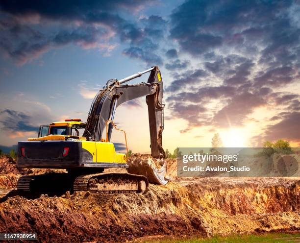 excavator at the construction site in the evening. - larva imagens e fotografias de stock