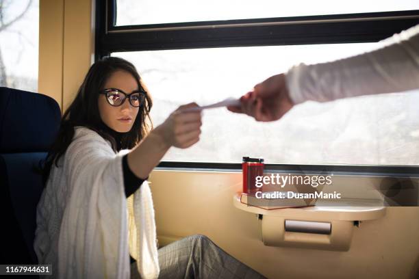 young woman traveling by train, having her ticket checked by the train conductor - bus operator stock pictures, royalty-free photos & images