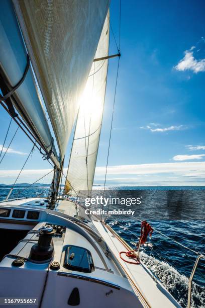 segeln mit segelboot in richtung sonne - mast sailing stock-fotos und bilder