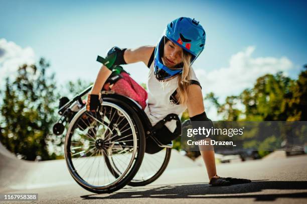 stunt-woman in wheelchair - wheelie imagens e fotografias de stock