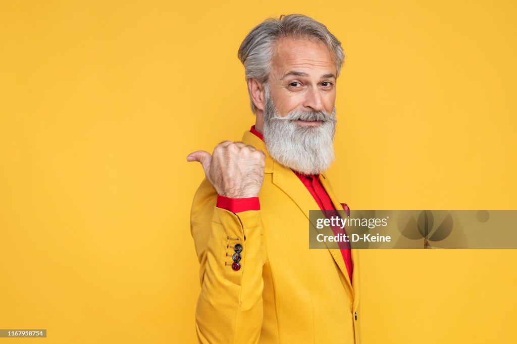 Happy well dressed gentleman having photoshooting in studio