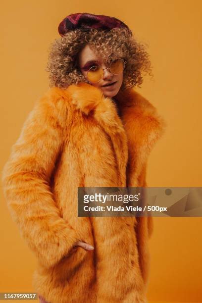 portrait of a woman in yellow tones - woman in fur coat stock-fotos und bilder