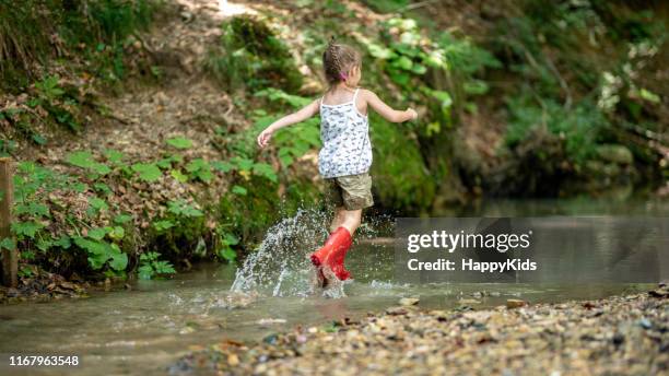 girl playing in water - innocence stock pictures, royalty-free photos & images