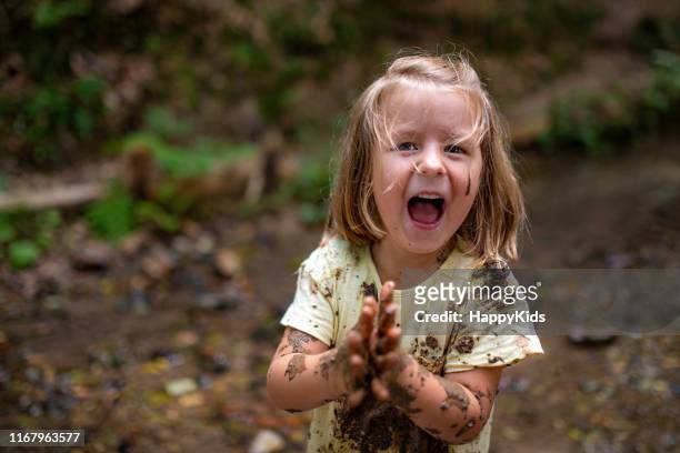 glimlachend meisje spelen in het bos - happy dirty child stockfoto's en -beelden