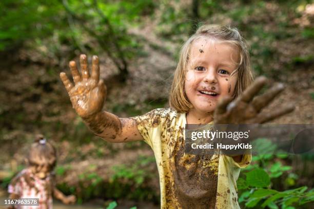 chica sonriente jugando en el bosque - lodo fotografías e imágenes de stock
