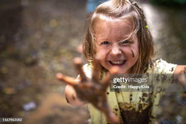 glimlachend meisje spelen in het bos - happy dirty child stockfoto's en -beelden