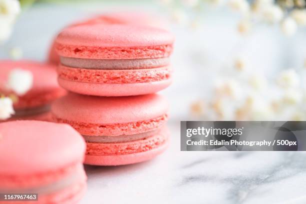 coral cakes macarons or macaroons on white marble spring background, copy space - macarons stock pictures, royalty-free photos & images