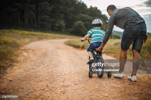 father and son spending time in nature - cycling class stock pictures, royalty-free photos & images