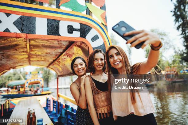 millennial frauen in mexiko genießen tag in xochimilco gärten - df stock-fotos und bilder