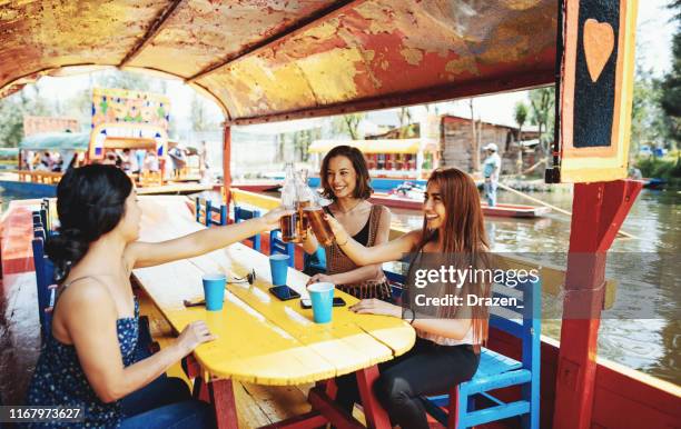 millennial women in mexico enjoying day in xochimilco gardens - mexico city tourist stock pictures, royalty-free photos & images