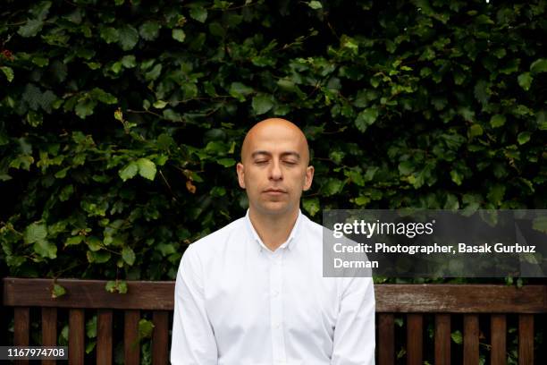 a serious middle aged bald men with eyes closed - vollglatze stock-fotos und bilder