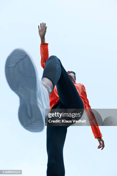 sportsman with legs apart against clear sky - low angle view shoe stock pictures, royalty-free photos & images