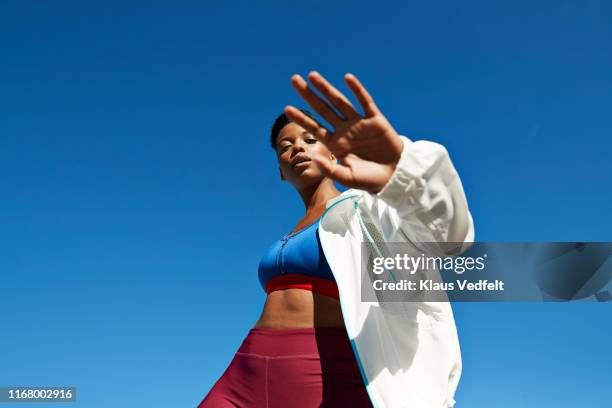 sportswoman wearing jacket with sports clothing against clear sky - hand on hip bildbanksfoton och bilder