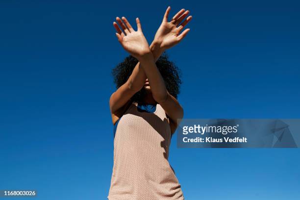 directly below shot of female athlete gesturing against clear sky - persona irriconoscibile foto e immagini stock