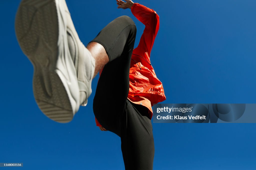 Athlete running against clear blue sky on sunny day