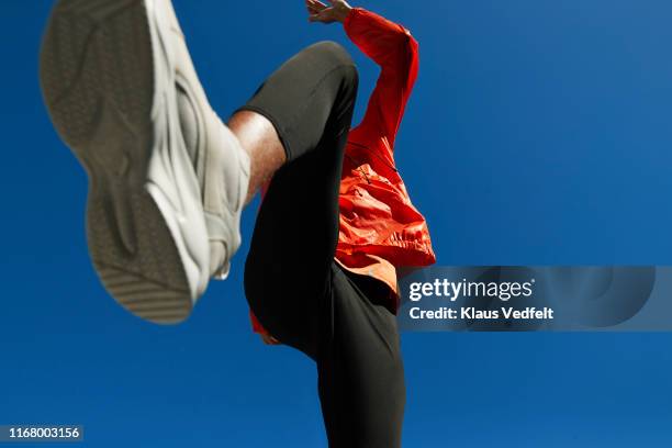 athlete running against clear blue sky on sunny day - blauwe schoen stockfoto's en -beelden