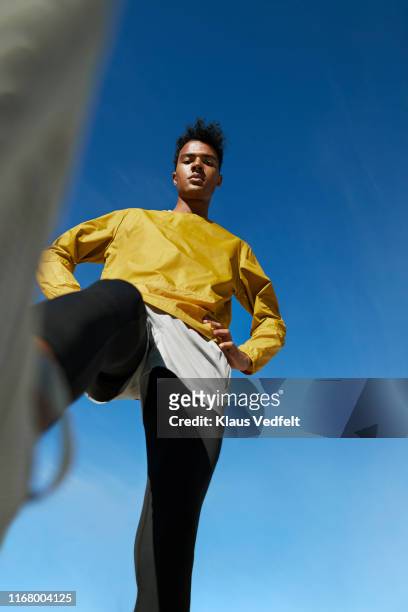 directly below portrait of sportsman against clear sky - yellow trousers stock-fotos und bilder