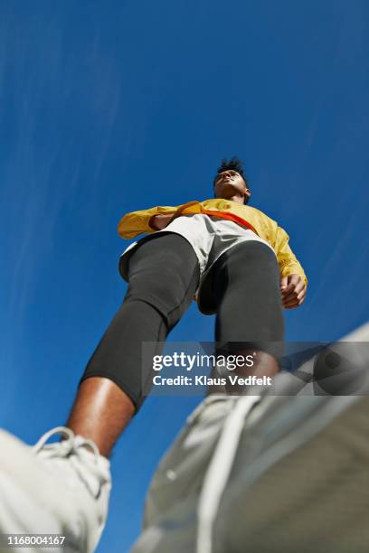 athlete looking away against clear sky - low angle view man stock pictures, royalty-free photos & images