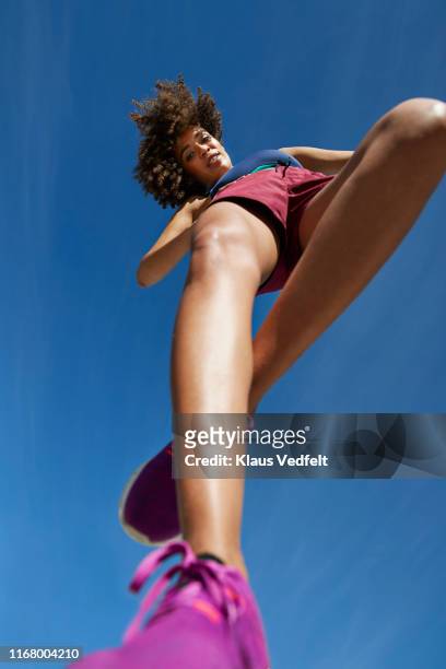 directly below portrait of sportswoman on sunny day - calções azuis imagens e fotografias de stock