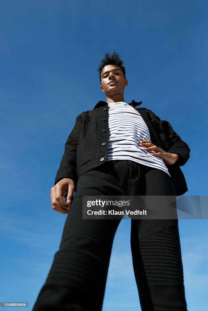 Portrait of fashionable man standing against blue sky