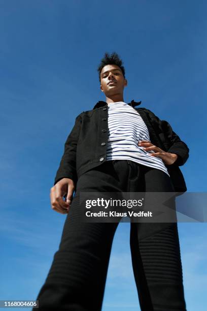 portrait of fashionable man standing against blue sky - vue en contre plongée photos et images de collection
