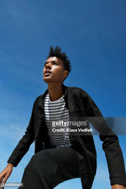 fashionable man looking away against blue sky - blue jacket stock pictures, royalty-free photos & images