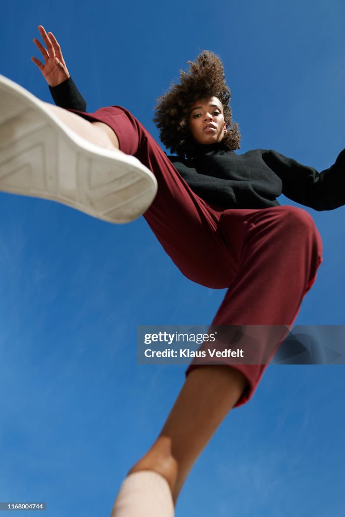 Portrait of woman wearing casuals against blue sky