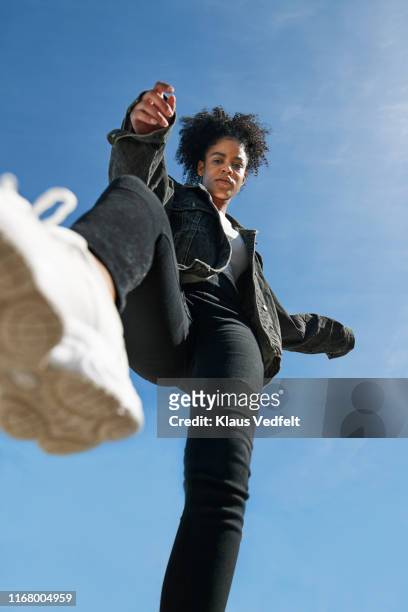 young woman wearing casuals against blue sky - portrait of young woman standing against steps stock pictures, royalty-free photos & images