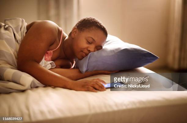 desligar o alarme - black man sleeping in bed - fotografias e filmes do acervo